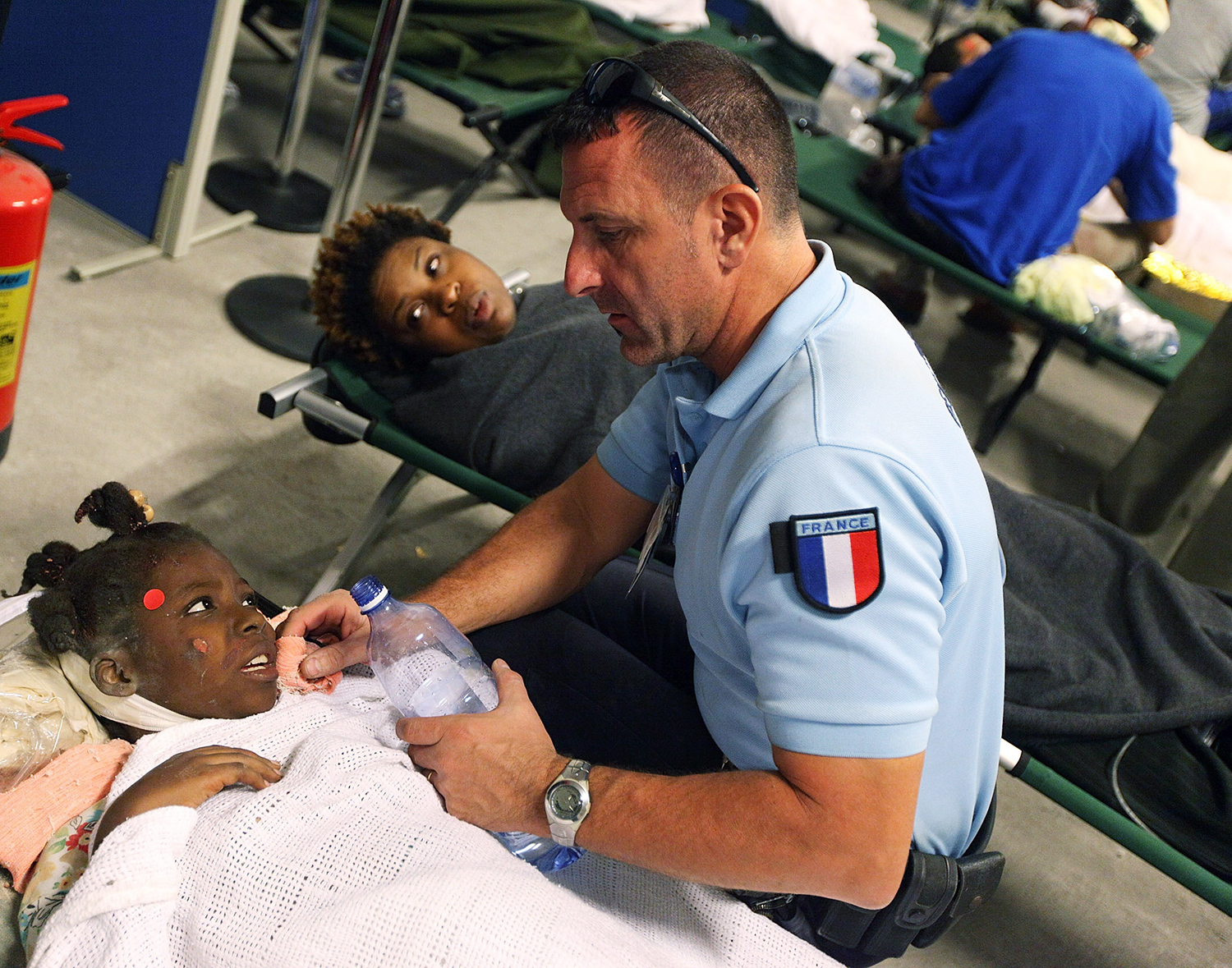 Photo of aid worker helping girl in Port-au-Prince, Haiti, on January 13, 2010.