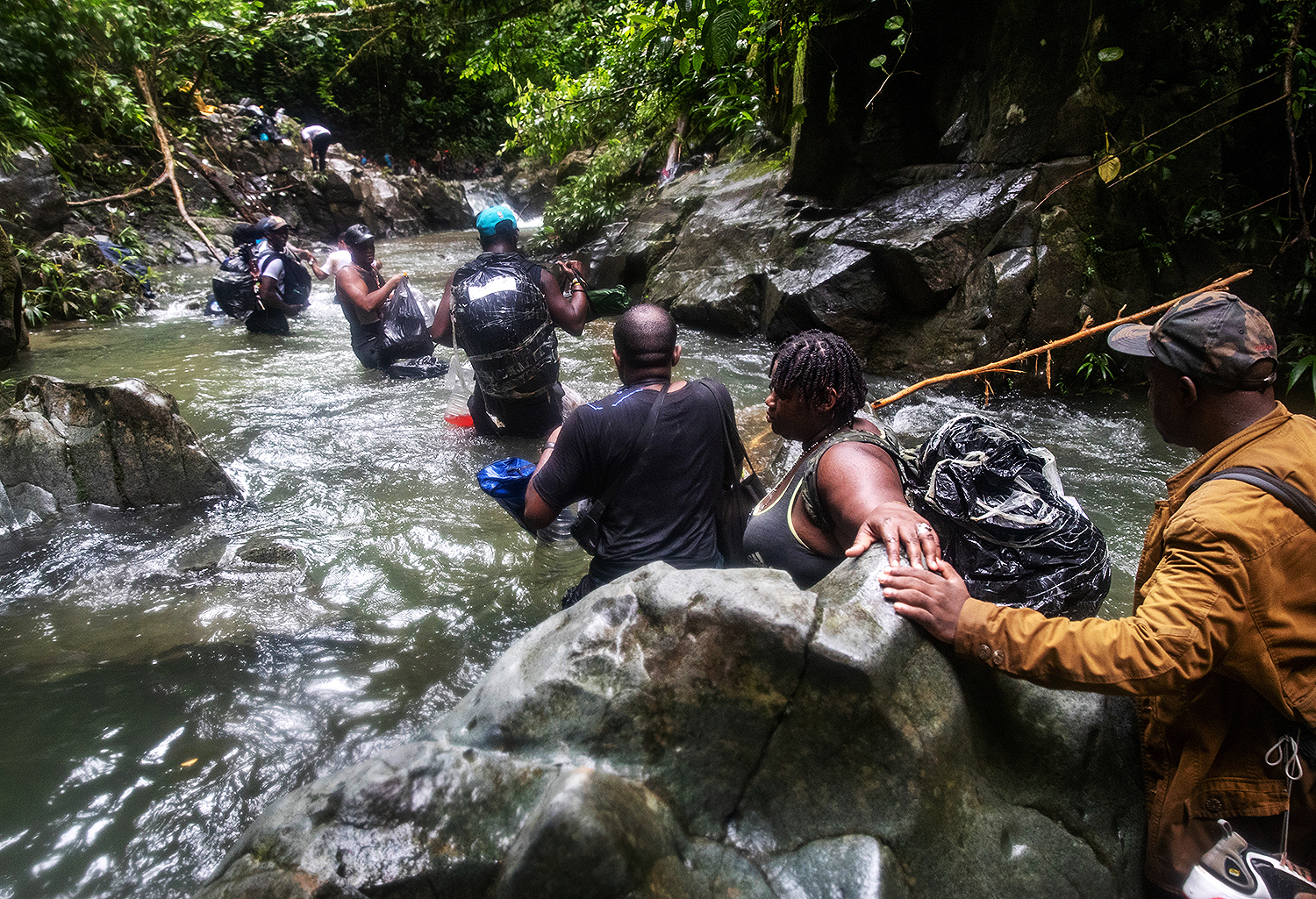Photo of families crossing river in Darien Gap, Colombia, on October 18, 2021.