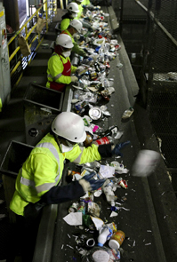 Workers sorting plastic on a conveyer belt