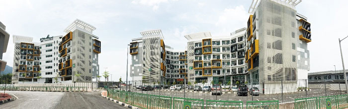 A photo shows a panorama of two buildings with a road in between the buildings.