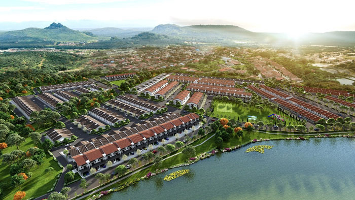 A photo shows a top view of several arrays of terrace houses overlooking a lake in Sungai Siput town. Mountains and trees behind the housing area are visible in the photo.