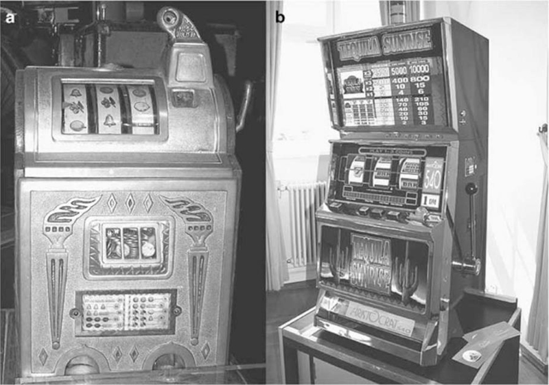 A photo on left (labeled “a”) shows a roll-a-top jackpot slot machine having rolls with fruit images and a box filled with coins. A photo on right (labeled “b”) shows a “Tequila Sunrise” arcade game machine.