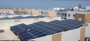 An aerial view of solar panels installed on the rooftops of residential buildings.