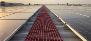 An aerial view of solar panels installed on the rooftop of a commercial building.