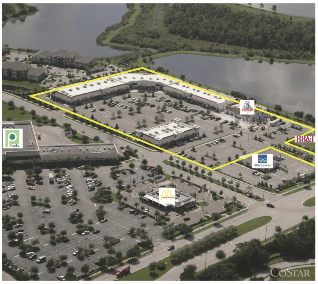 An image shows the aerial view of Tulaberry Plaza (outline marked in a different color). Logos of Publix, McDonalds, Wachovia, BB&T and Outback steak house are given above appropriate buildings. Many cars and trees are seen in between the buildings.